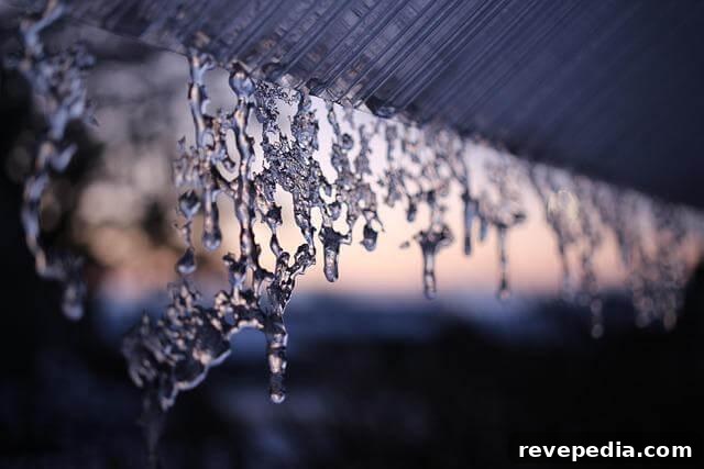 Flashing Leak Repair Guide: Identify Causes and Fixes 2 Water drops hanging from a roof, indicating a flashing