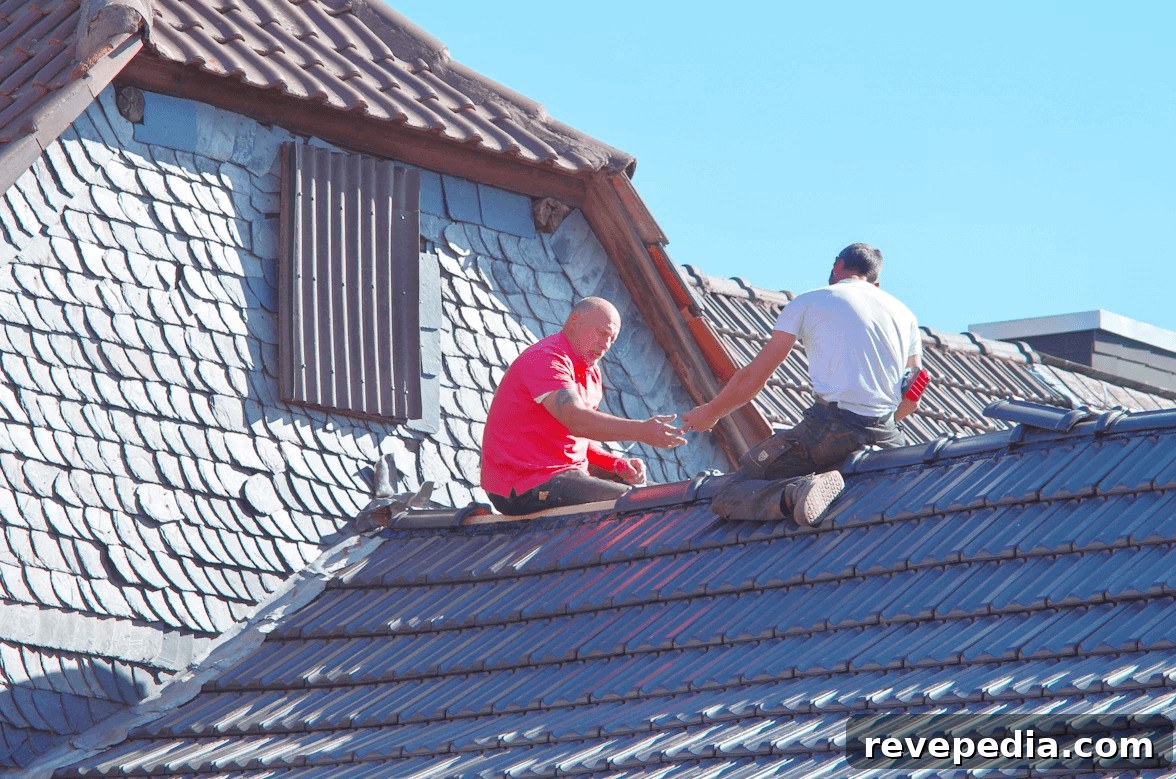 Two men installing roofing material on a house roof