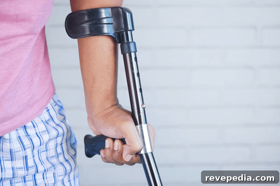 Person holding a crutch and walking cane after