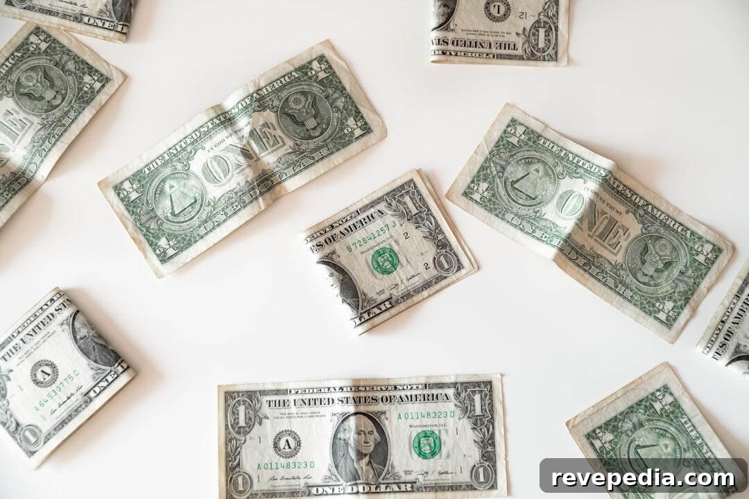 Several US one-dollar bills scattered across a plain white background