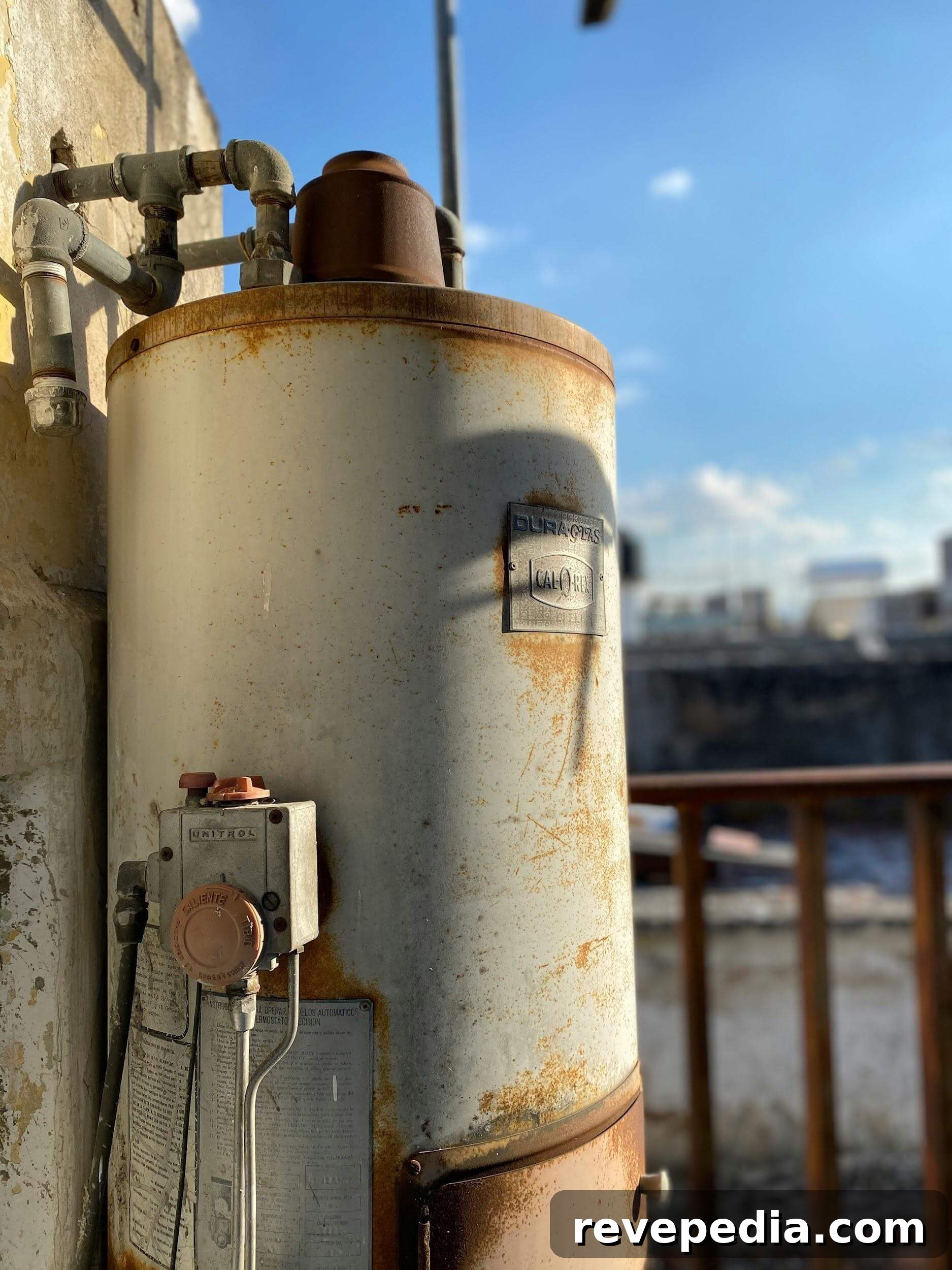 Gas vs Electric Water Heaters: Installation and Operating Costs 3 Old, rusty water heater tank next to a