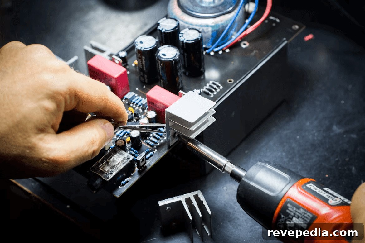 Person working on an electronics circuit board, highlighting DIY